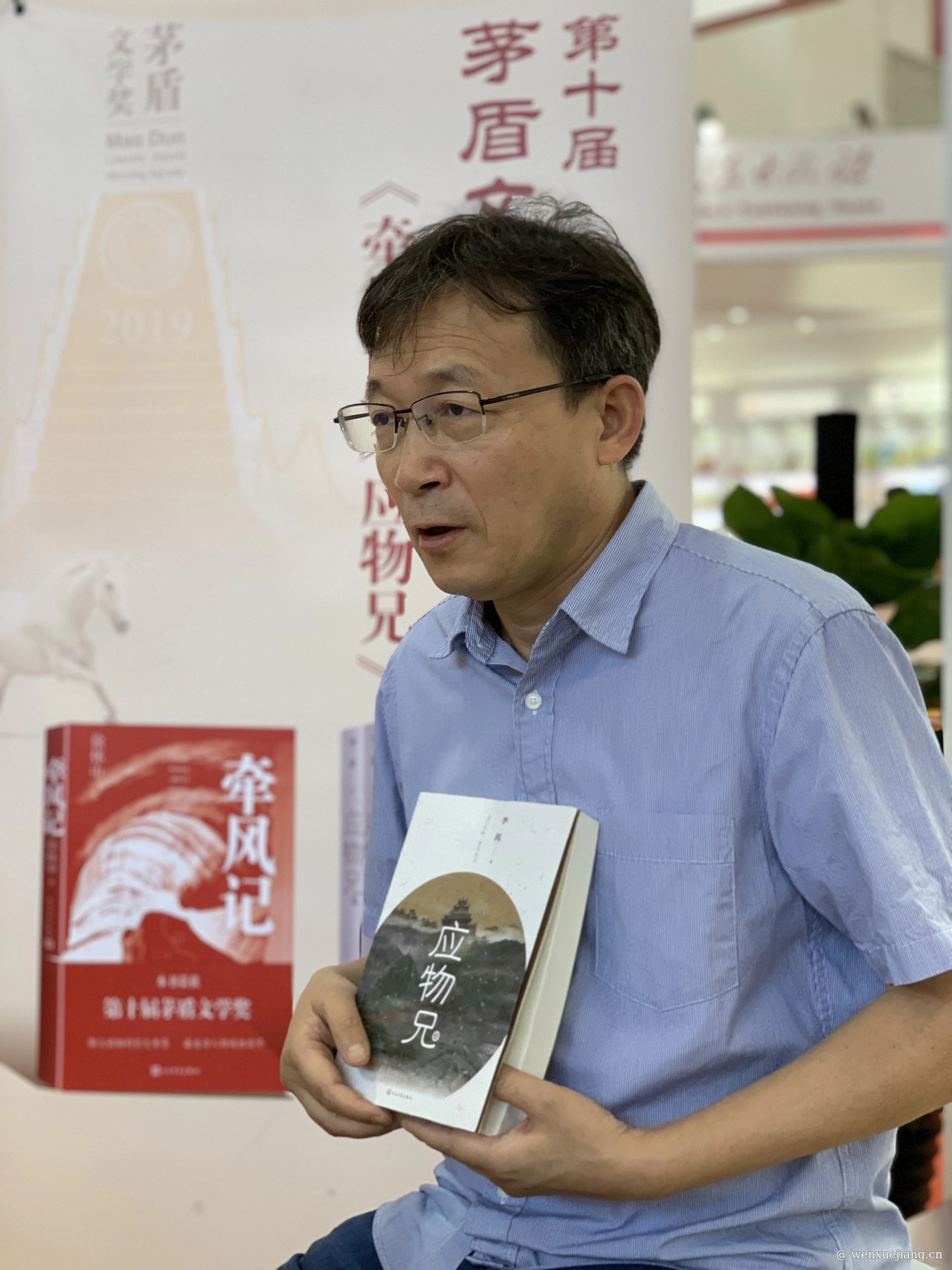 <p>手执自己作品的李洱</p>